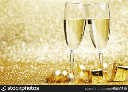 Champagne glasses and gifts on glitters background