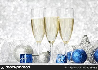Champagne glasses and new year decoration on silver bokeh background
