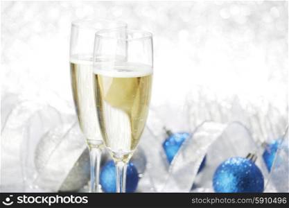 Champagne glasses and new year decoration on silver bokeh background