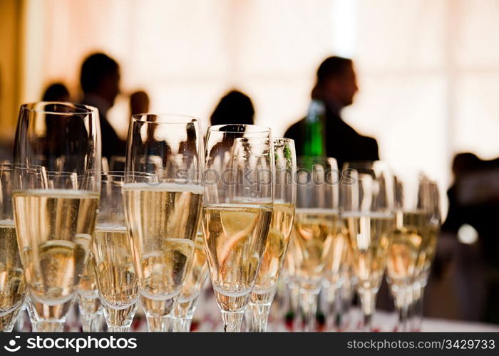 Champagne glasses at the party. People celebrate in the background