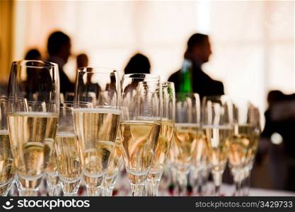 Champagne glasses at the party. People celebrate in the background