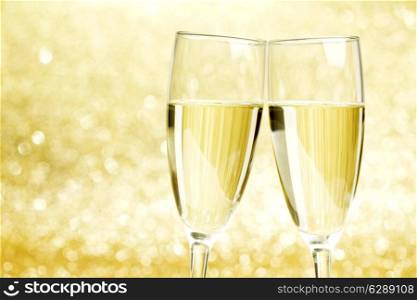 Champagne glasses on abstract shiny glitters background