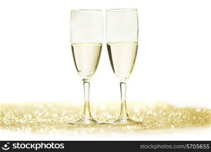 Champagne glasses on glitters isolated on white background