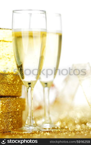 Champagne in glasses and gift box on golden background with twinkle lights