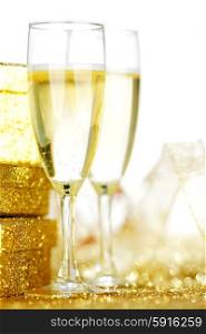Champagne in glasses and gift box on golden background with twinkle lights