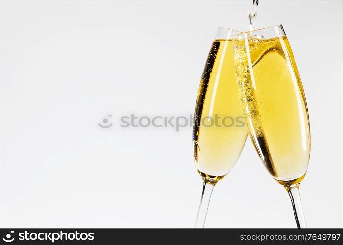 Champagne pouring in two glasses New Year celebration. Champagne pouring in two glasses