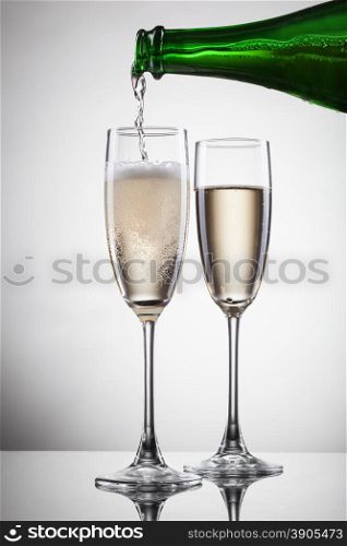 Champagne pouring into glass isolated on white