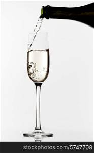 Champagne pouring into glass on a white background. Champagne pouring