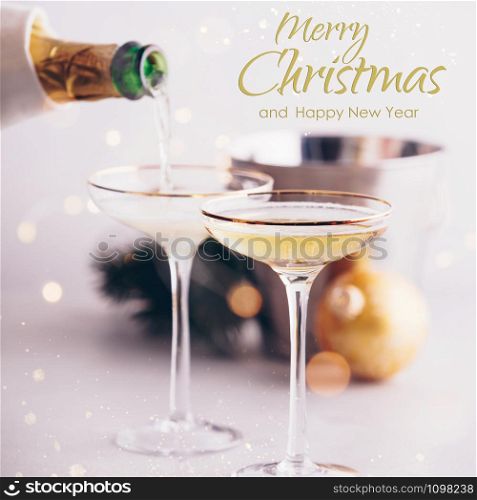 Champagne pouring into glasses and Christmas decorations on concrete background. Champagne pouring into glasses and Christmas decorations with text