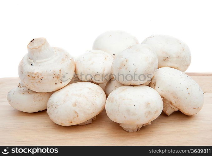 Champignon cooking mushrooms on wooden chopping board isolated on white background