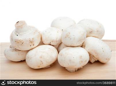 Champignon cooking mushrooms on wooden chopping board isolated on white background