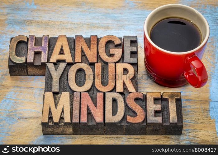 change your mindset - motivational text in vintage letterpress wood type printing blocks stained by color inks with a cup of coffee