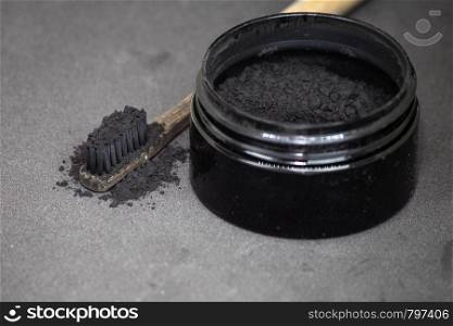 Charcoal on a toothbrush to whiten teeth beauty concept. Charcoal on a toothbrush to whiten teeth