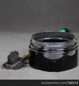 Charcoal on a toothbrush to whiten teeth beauty concept. Charcoal on a toothbrush to whiten teeth