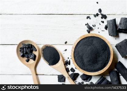Charcoal powdered wood, put on a cup, placed on a white table.