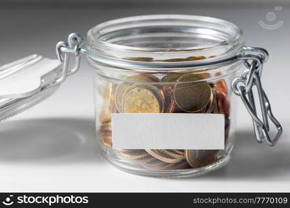 charity, donation and saving concept - close up of coins in glass jar. coins in glass jar for donation or saving