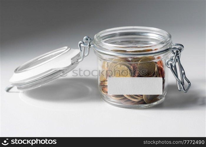 charity, donation and saving concept - close up of coins in glass jar. coins in glass jar for donation or saving