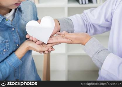 charity, health care, donation and medicine concept - doctor man hand giving heart to patient