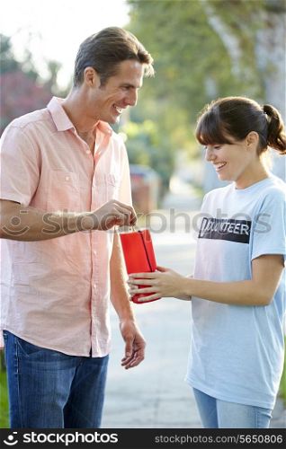Charity Worker Collecting From Man In Street