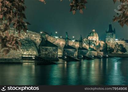 Charles Bridge and Old Town bridge tower at night in Prague, Czech Republic. Toning in cool tones
