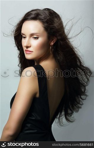 Charm. Aristocratic Lady in Black Dress and Flowing Hair