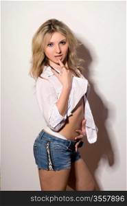 Charming blond young woman in a white shirt