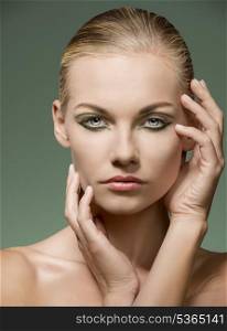 charming blonde girl posing in beauty shoot with naked shoulders, perfect freshness skin and creative green make-up
