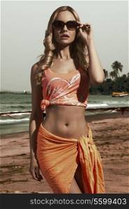 charming blonde lady with shiny wavy hair posing with orange pareo and sexy singlet in summer concept shot