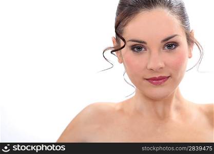 charming brunette posing with bare shoulders against studio background