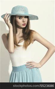 charming brunette woman with spring style wearing blue hat and skirt, yellow make-up and sensual pose