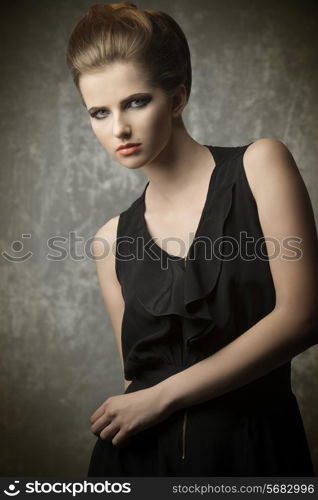 charming female posing in fashion portrait with elegant creative hair-style, stylish make-up and black dress