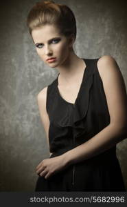 charming female posing in fashion portrait with elegant creative hair-style, stylish make-up and black dress