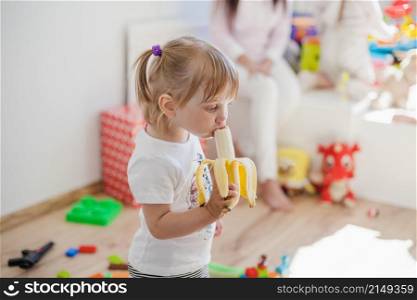 charming girl enjoying banana