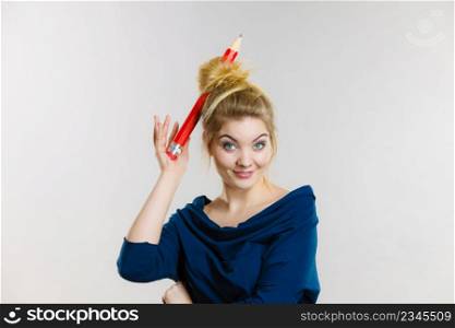 Charming happy blonde woman having big pencil in hair having fun, education ideas.. Happy blonde woman having big pencil in hair