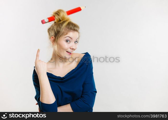 Charming happy blonde woman having big pencil in hair having fun, education ideas.. Happy blonde woman having big pencil in hair