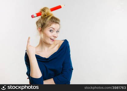 Charming happy blonde woman having big pencil in hair having fun, education ideas.. Happy blonde woman having big pencil in hair