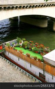 Charming houseboat with flowers docked on Seine in Paris, France