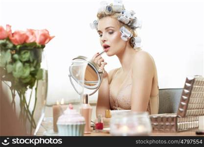Charming lady putting on a makeup