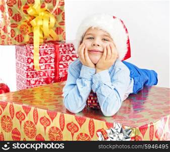 Charming little boy lying on Christmas present