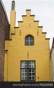 Charming old town house, looking up at yellow gable end. Bruges, West Flanders, Belgium, Europe