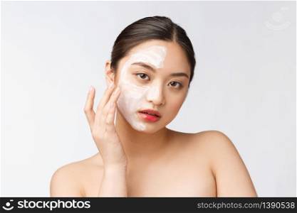 Charming pleasant woman applying cream on half face.. Charming pleasant woman applying cream on half face