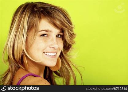 charming pretty girl smiling over a green background