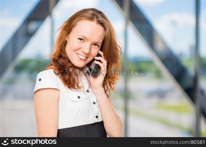 Charming secretary with a phone in his hand in the office