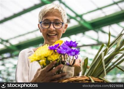 Charming senior woman buying fresh flowers on market