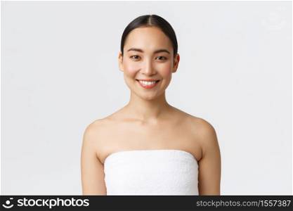 Charming smiling young asian woman in towel looking at camera happy as finish her daily skincare routine, standing bathroom over white background, going shower, attend spa salon.. Charming smiling young asian woman in towel looking at camera happy as finish her daily skincare routine, standing bathroom over white background, going shower, attend spa salon