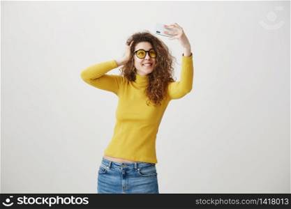 Charming stylish woman making selfie photo on smartphone isolated on a white background. Charming stylish woman making selfie photo on smartphone isolated on a white background.
