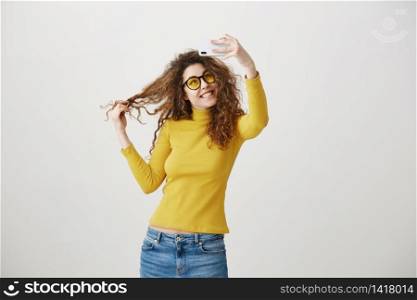 Charming stylish woman making selfie photo on smartphone isolated on a white background. Charming stylish woman making selfie photo on smartphone isolated on a white background.