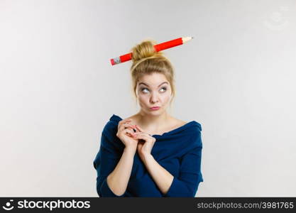 Charming thinking blonde woman having big pencil in hair having something on her mind, education ideas.. Thinking blonde woman having big pencil in hair