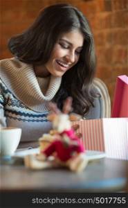 Charming woman in a restaurant opening gift from her couple, Christmas or Valentine's Day romantics