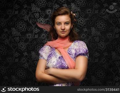 Charming woman over dark background with shawl on the wind and with hands crossed